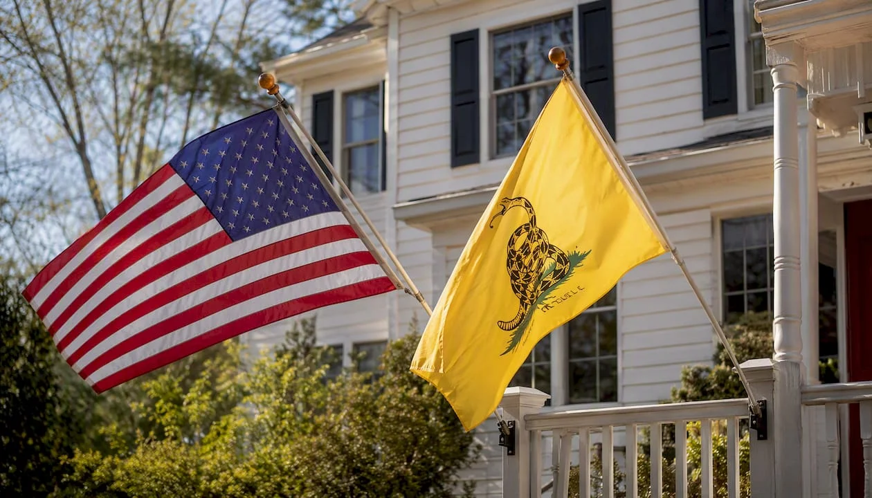 Two flags on equal-height staffs on a porch