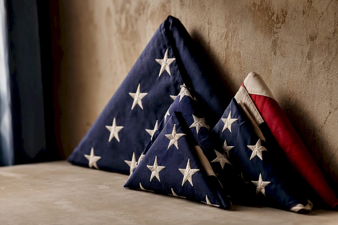 Stacked folded American flags of different sizes