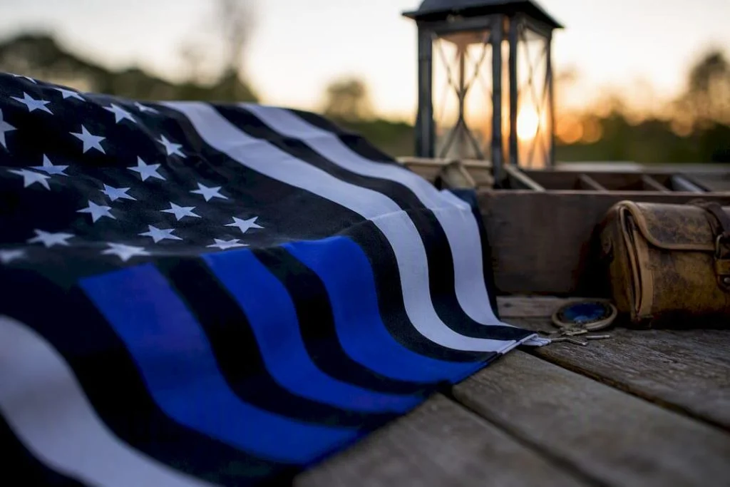 Folded thin blue line flag on wooden table