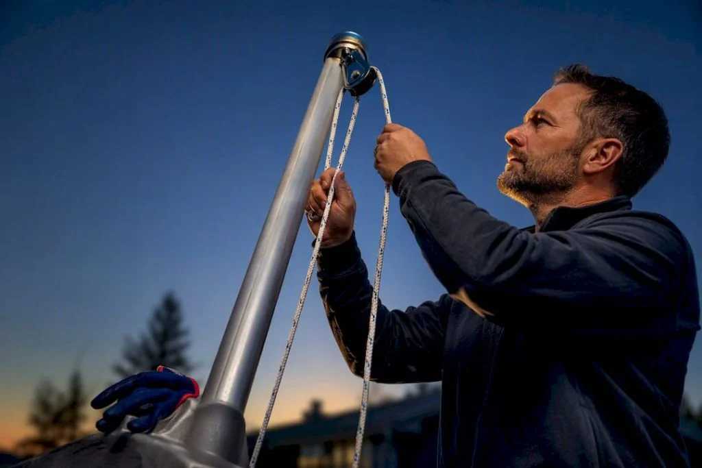 Homeowner threading rope through flagpole pulley
